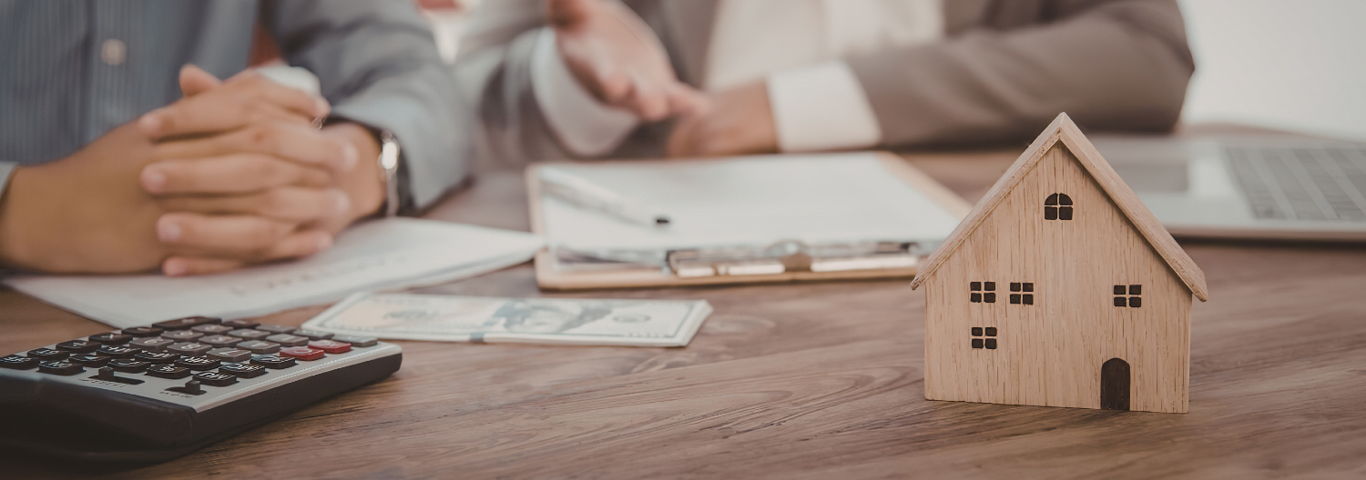 A person sitting at a table with a stack of papers.