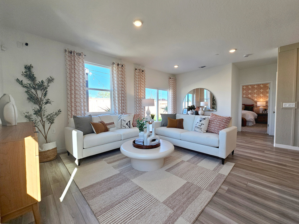 A living room with a rug and a large window.