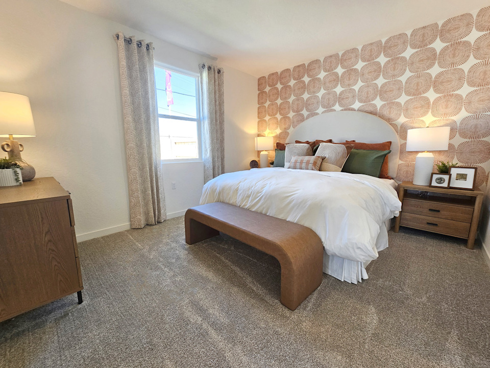 A bedroom with a bed and lamps.