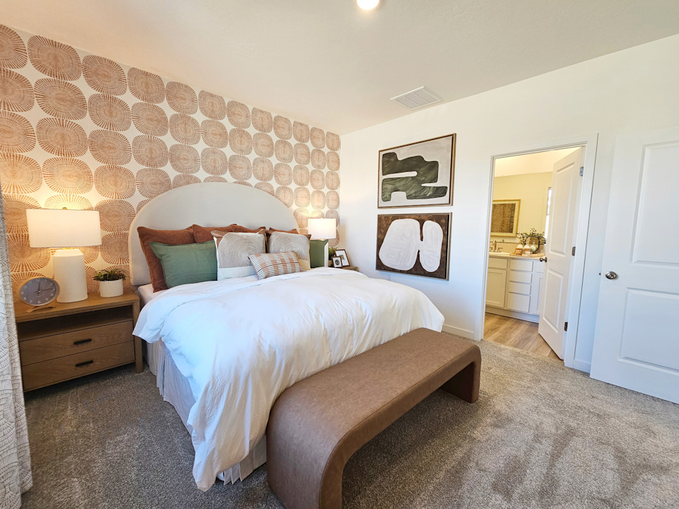 A bedroom with a bed and lamps.