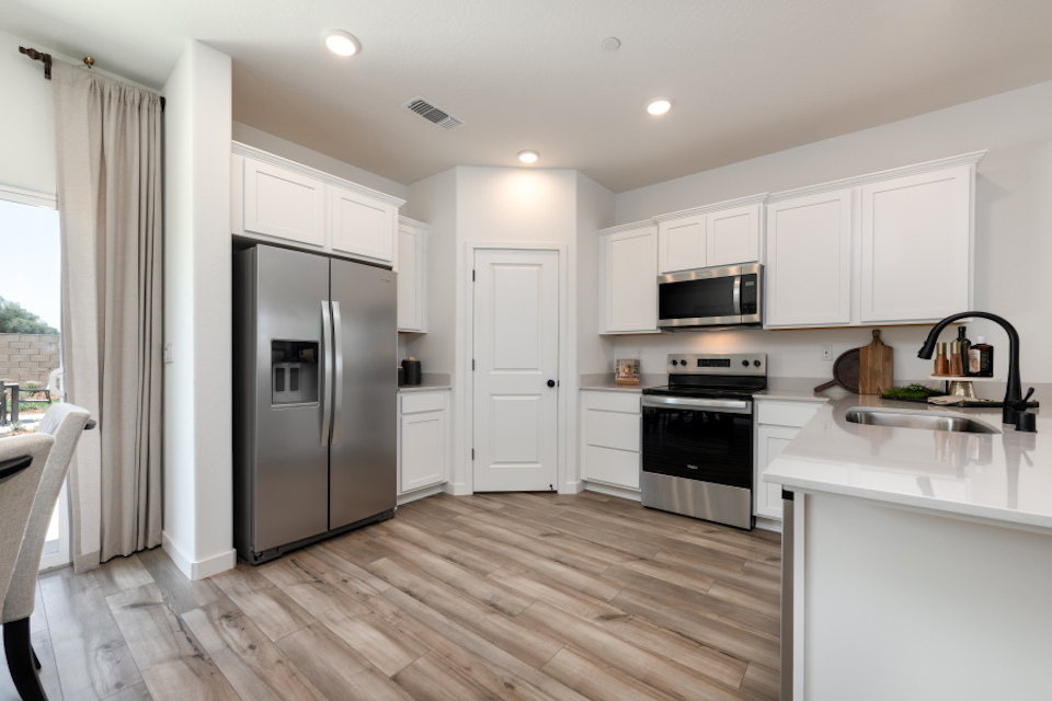 A kitchen with white cabinets.