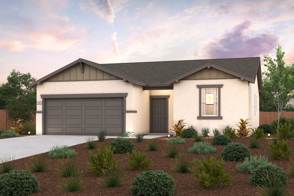 A house with a garage and bushes in front of it.