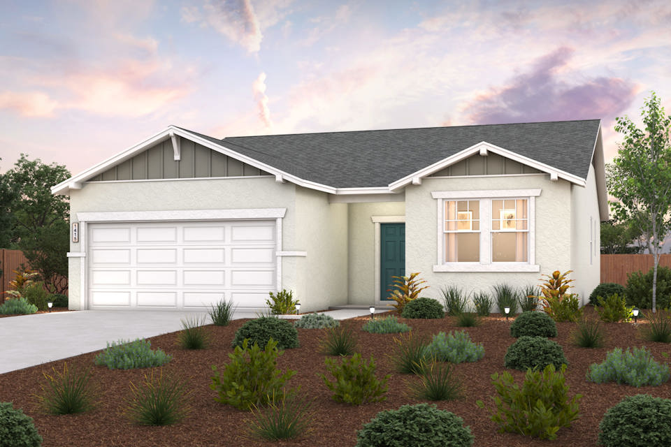 A house with a garage and bushes in front of it.