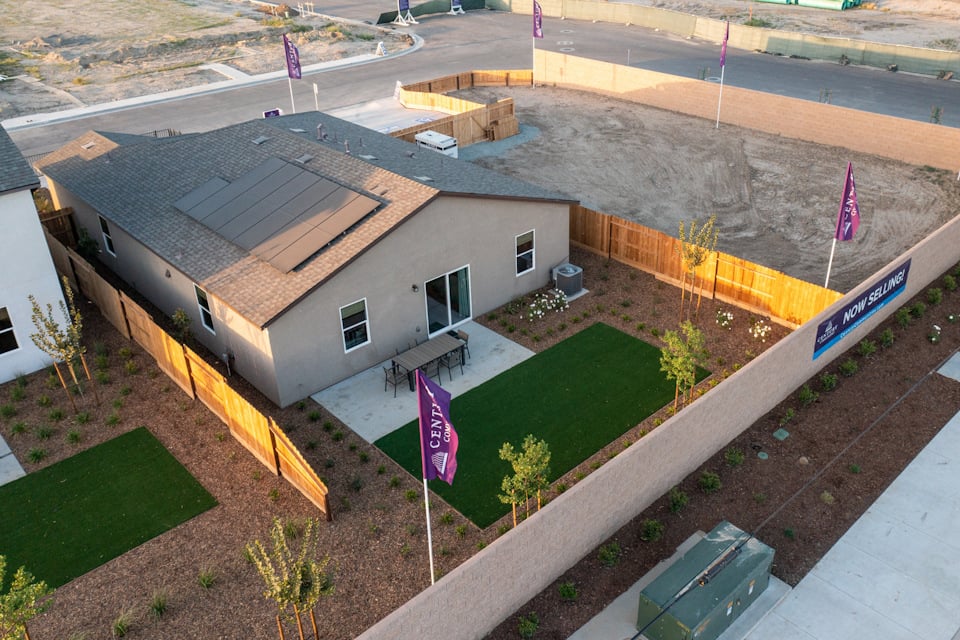 A house with a lawn and a parking lot.