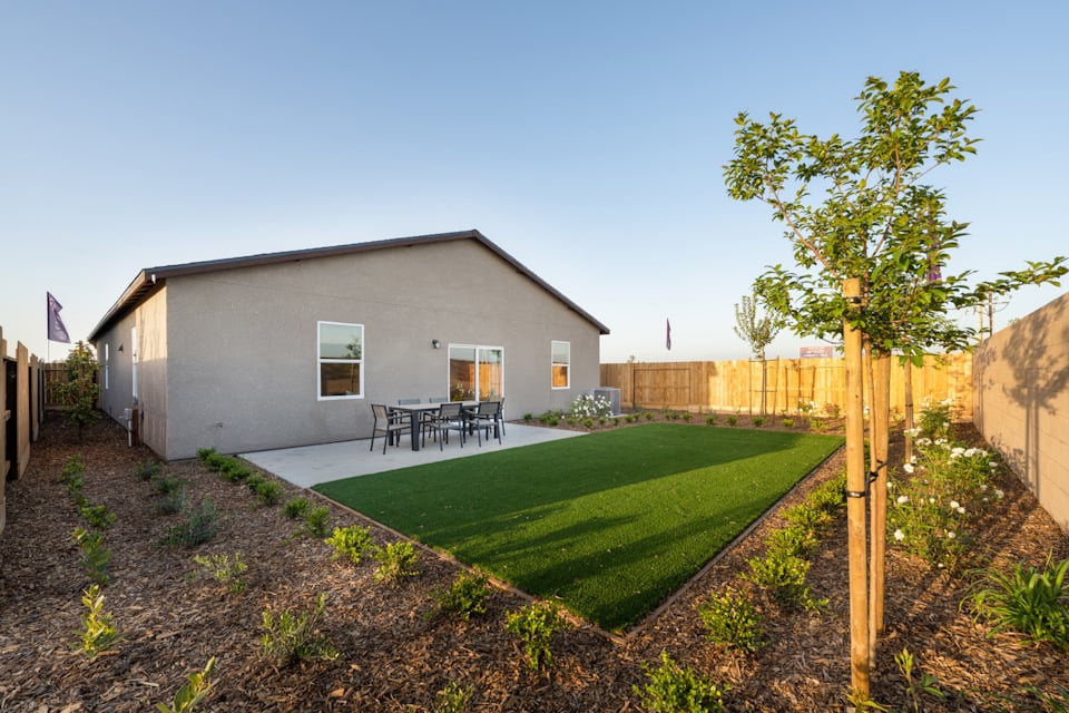 A backyard with a fence and a house.