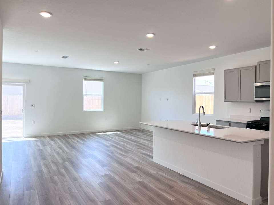 A large kitchen with a wood floor.