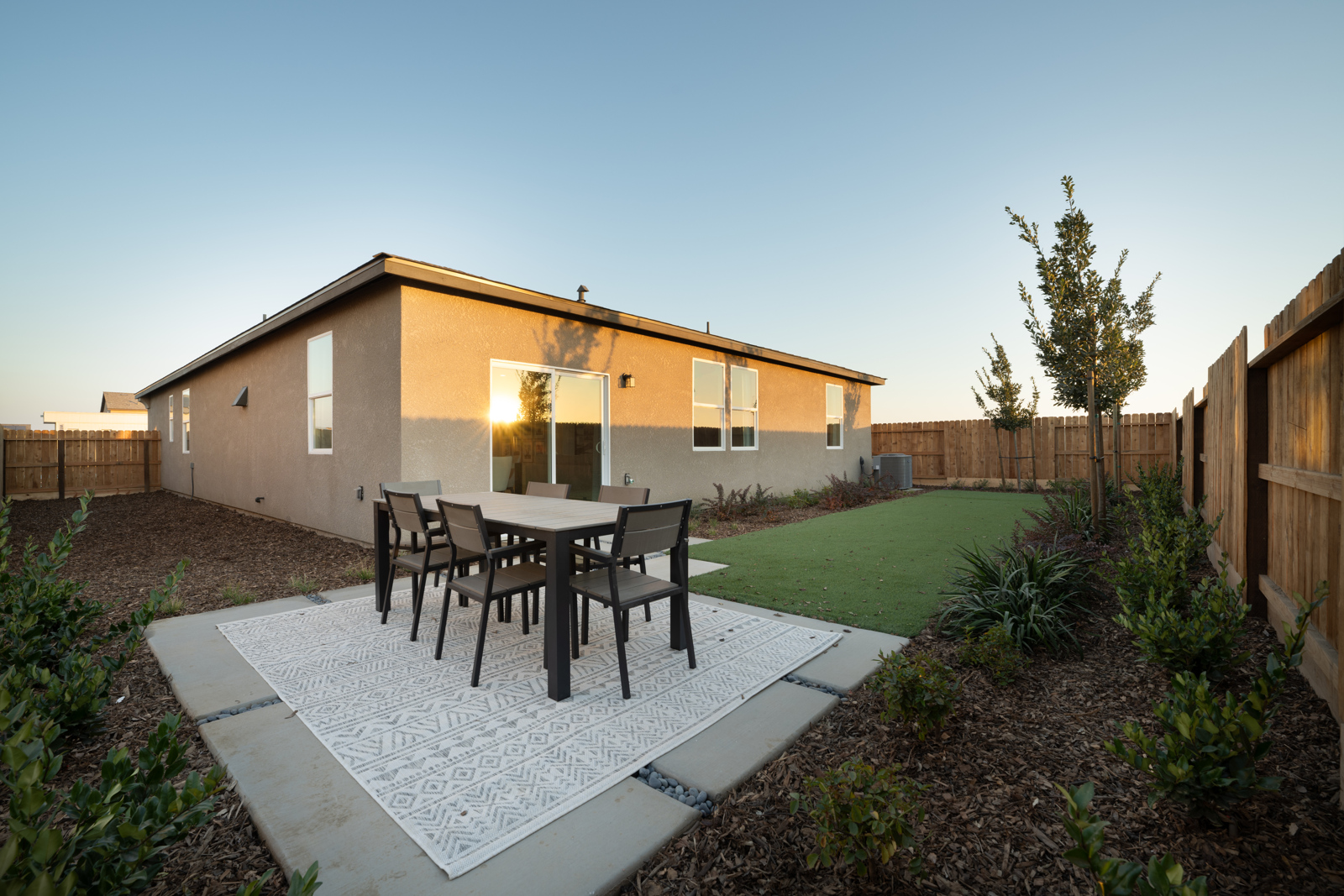 A house with a patio and a table and chairs in the front.