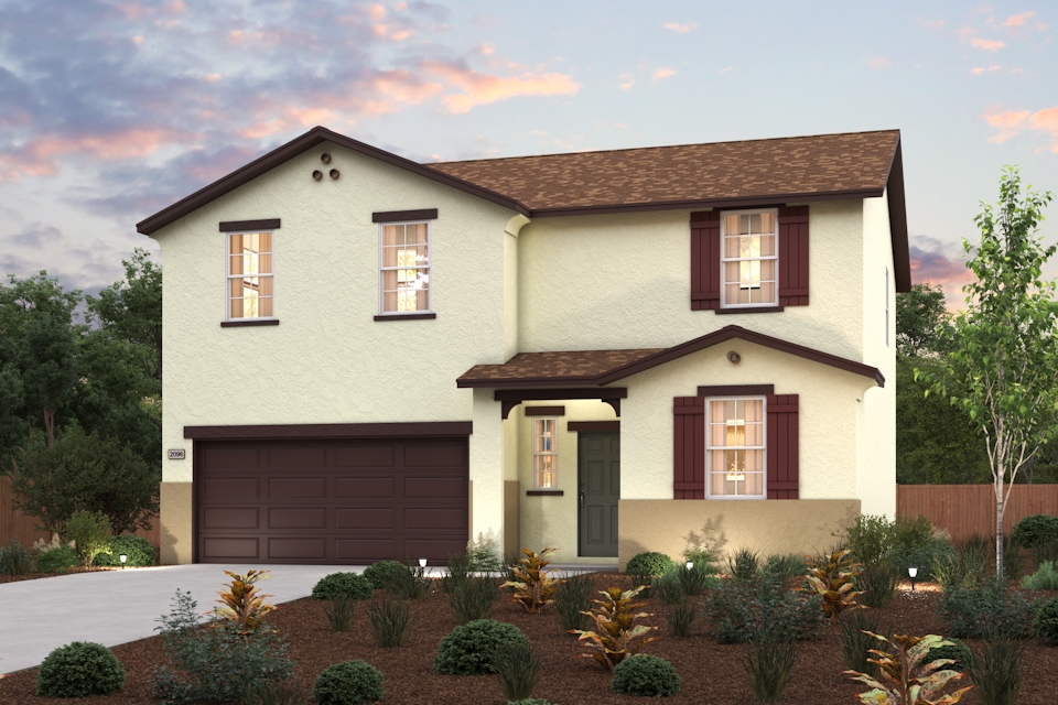 A house with a garage and bushes in front of it.