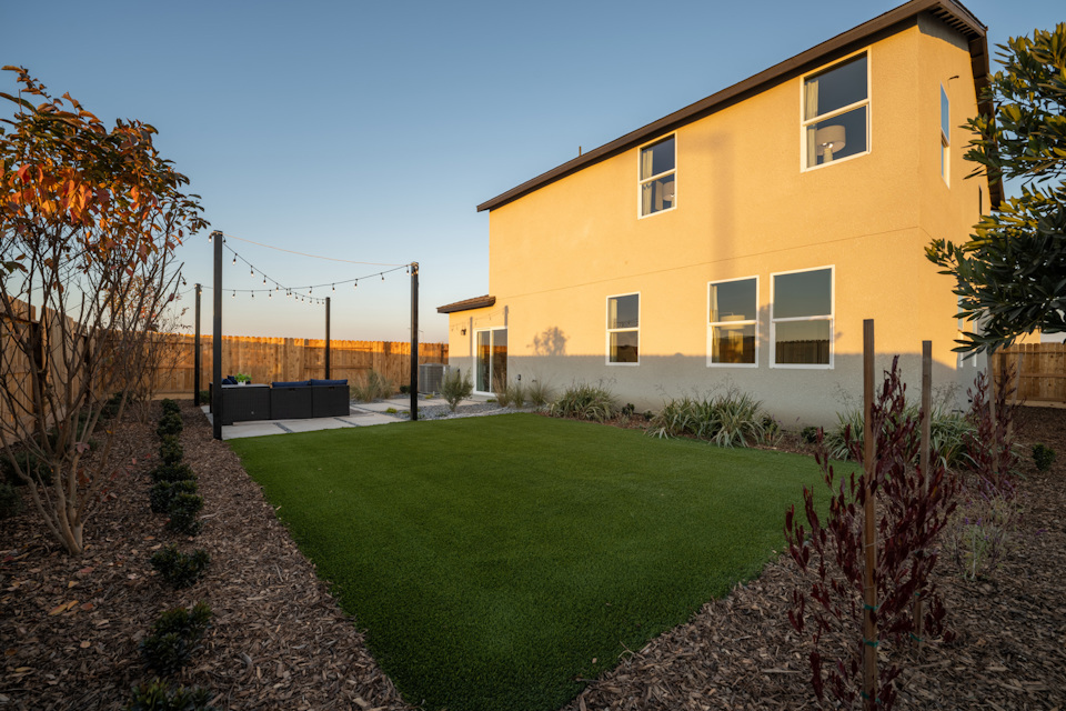 A yellow house with a green lawn.