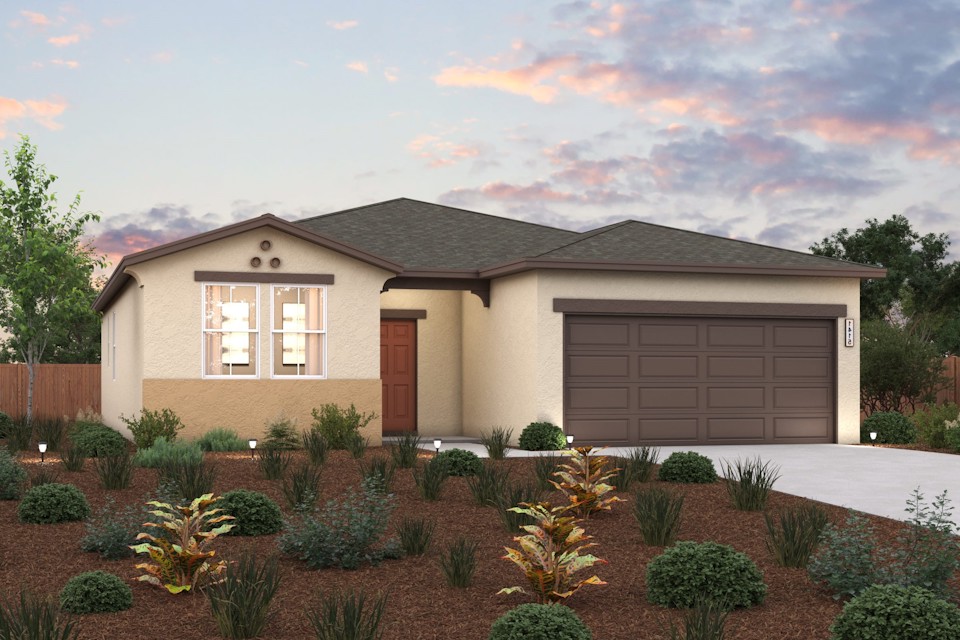 A house with a garage and bushes in front of it.