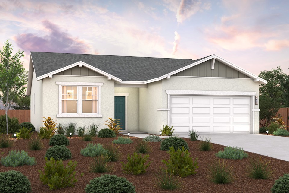 A house with a garage and bushes in front of it.