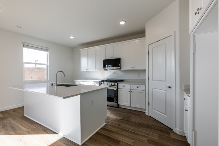 A kitchen with white cabinets.