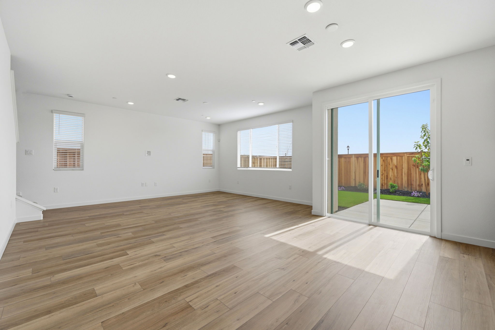 A room with a wood floor and a wood floor with a glass door.