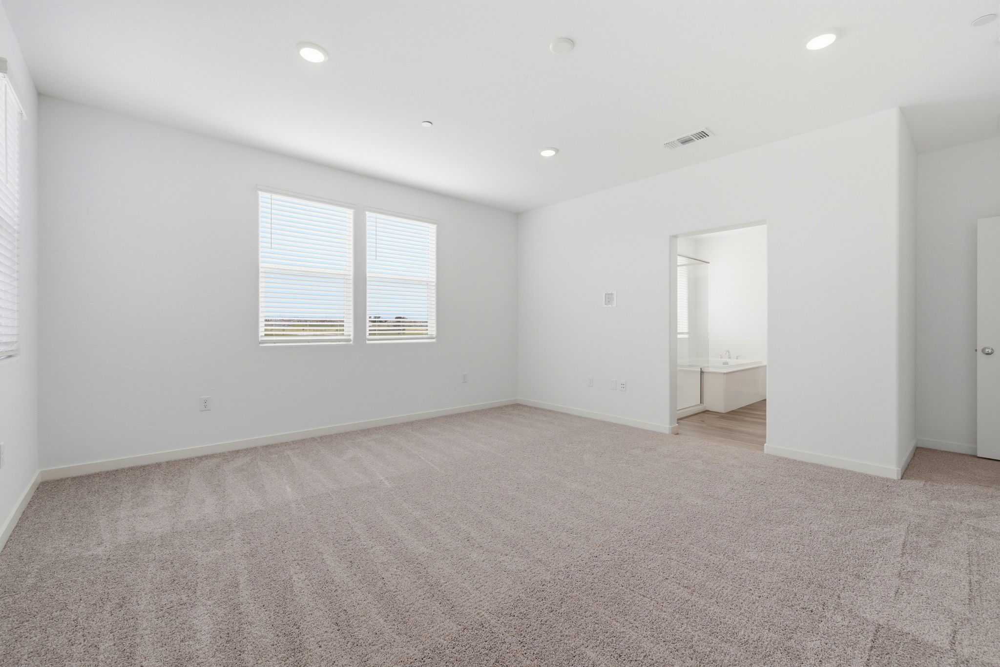 A room with a carpet and a door.