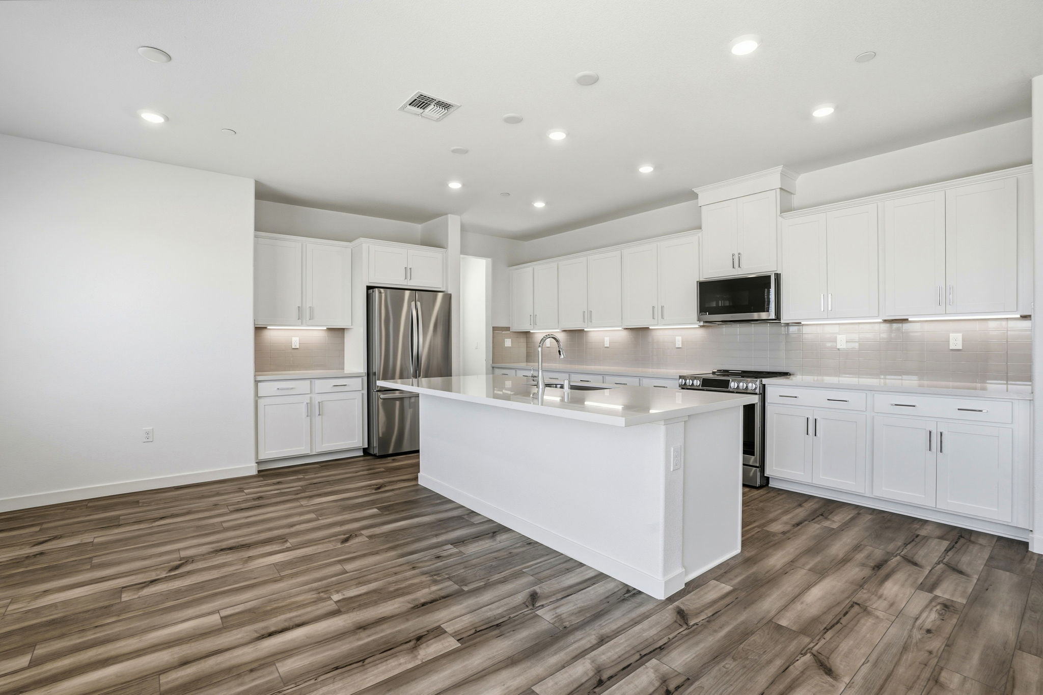 A kitchen with white cabinets.
