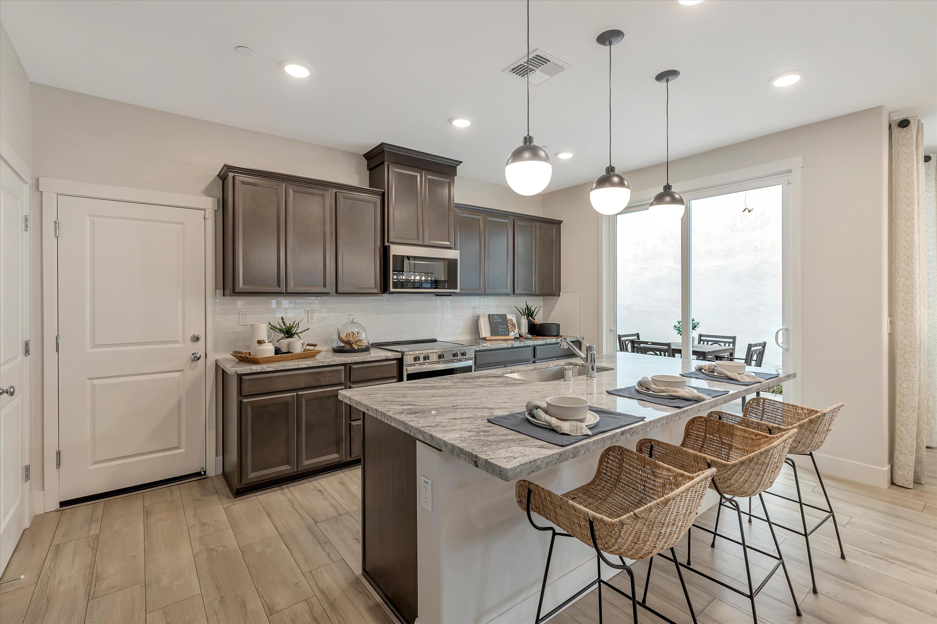 A kitchen with a island and chairs.