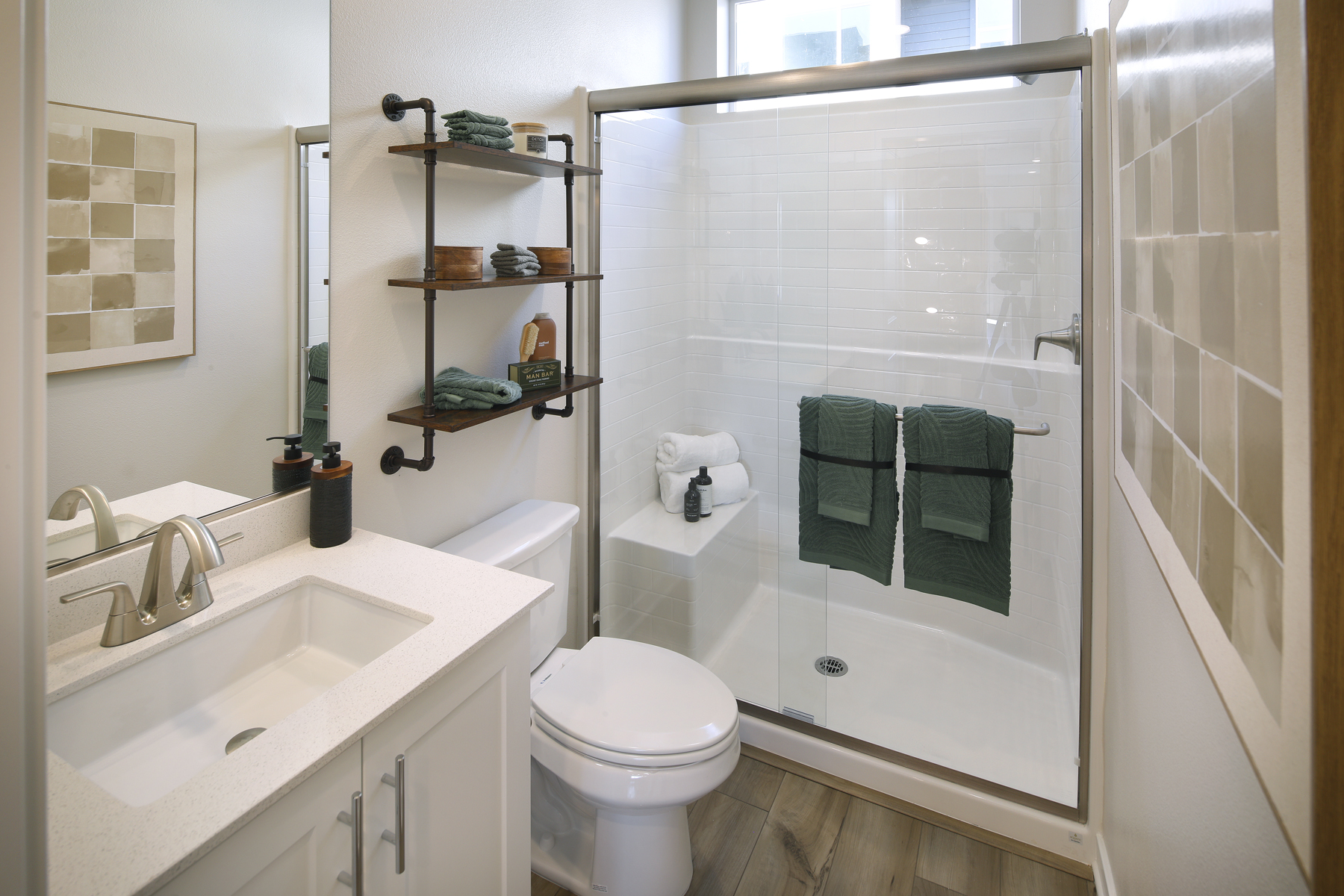A bathroom with a sink toilet and a shower.