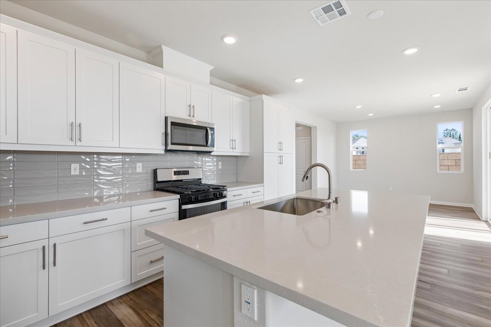 A kitchen with white cabinets.