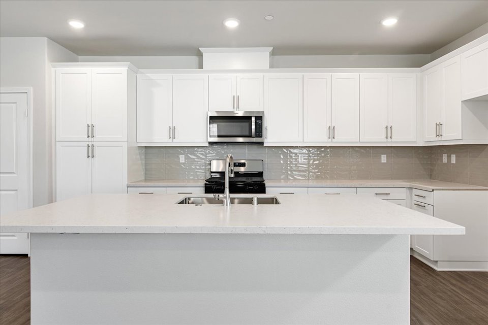A kitchen with white cabinets.