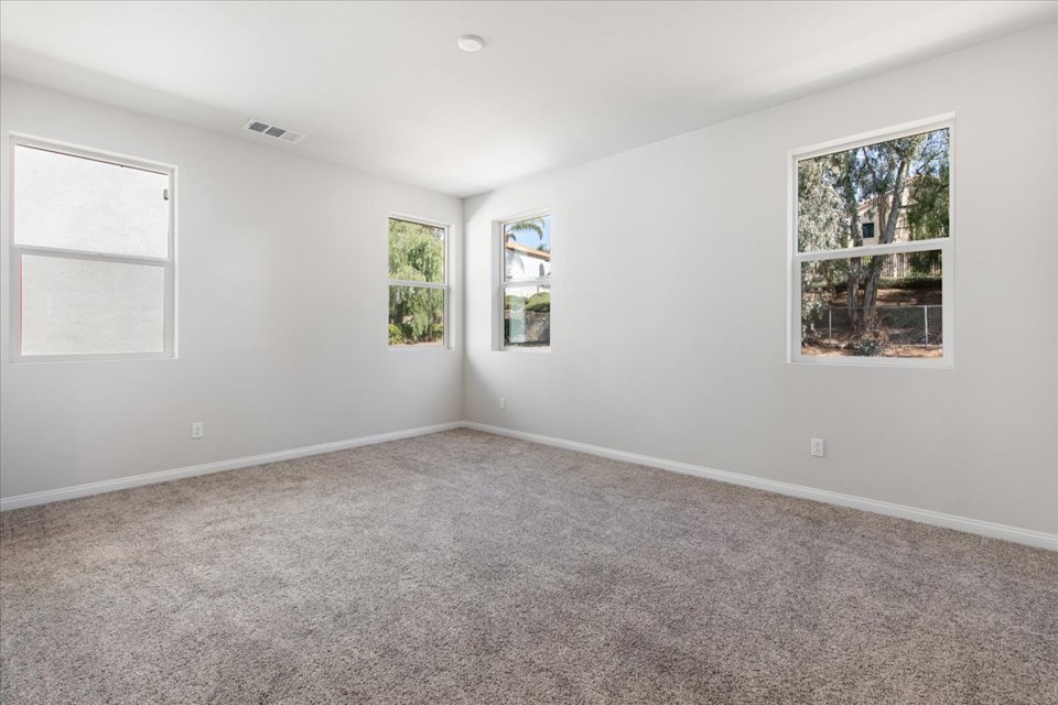 A room with a carpet and windows.