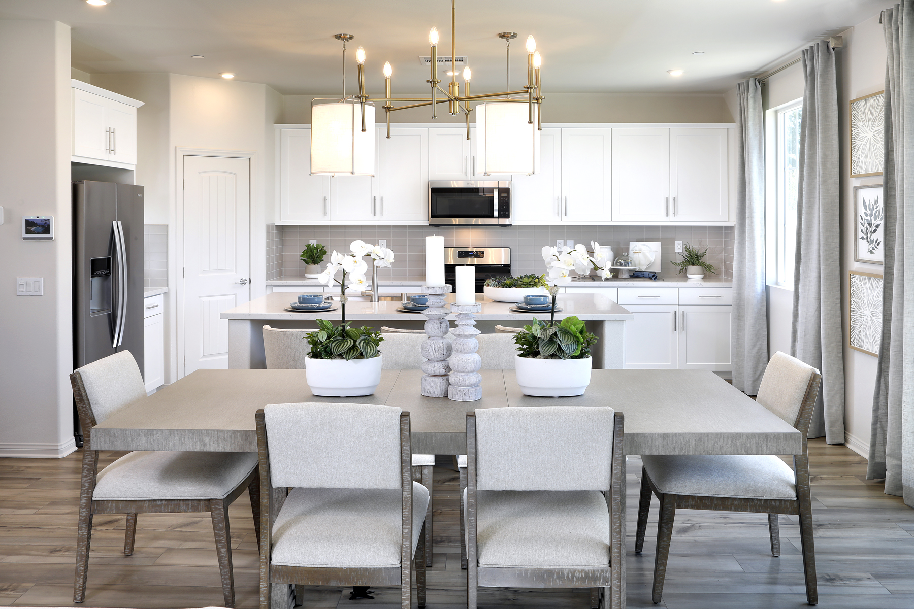 A kitchen with a dining table and chairs.
