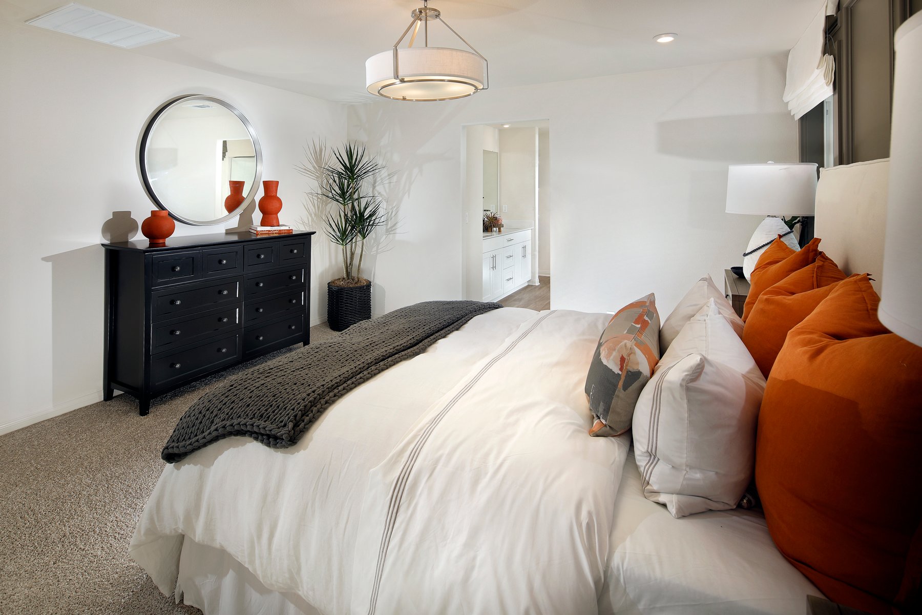 A bedroom with a bed and a mirror.