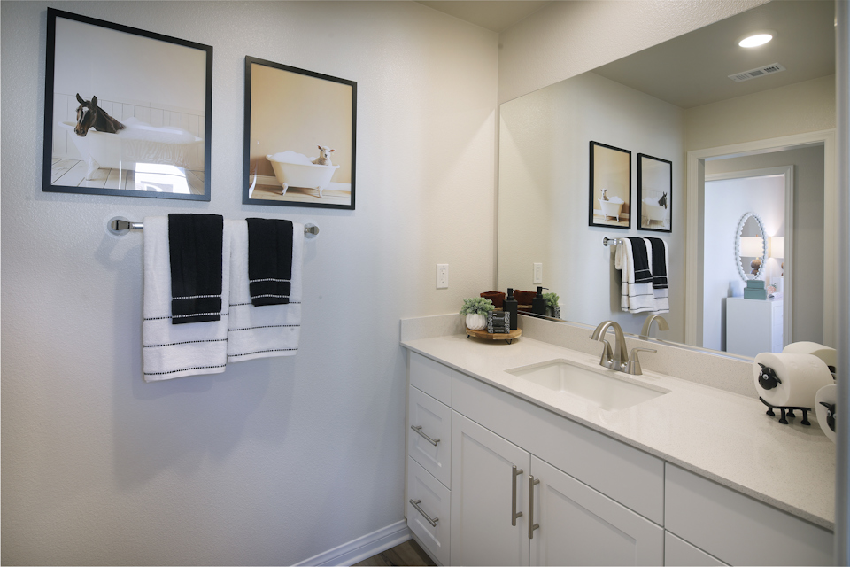 A bathroom with white cabinets.