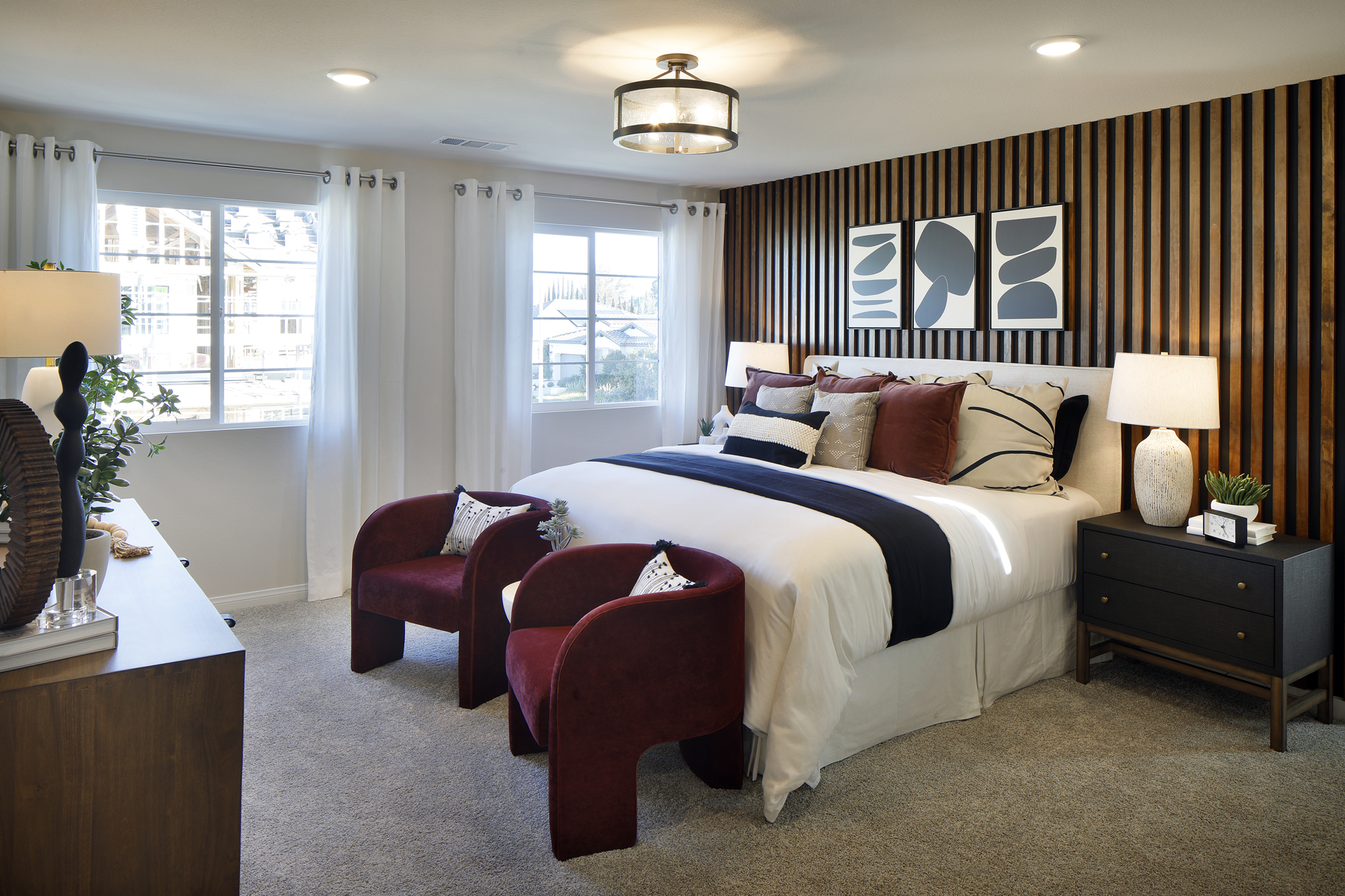 A bedroom with a bed and chairs.