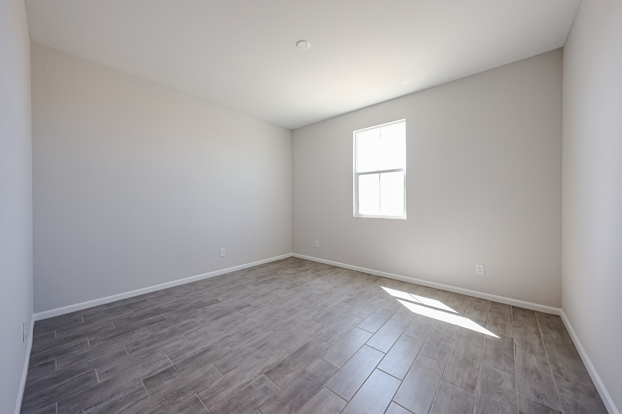 A room with a wood floor and windows.