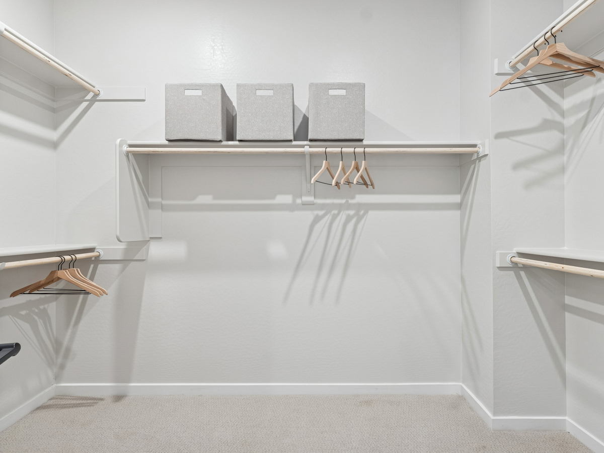 A white bathtub with a shelf and a mirror.