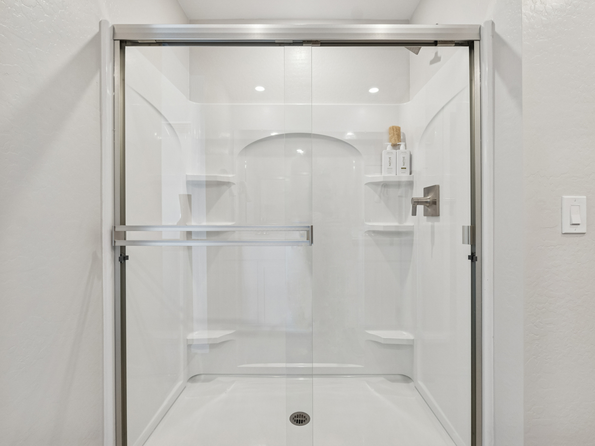 A glass shower with a glass door.