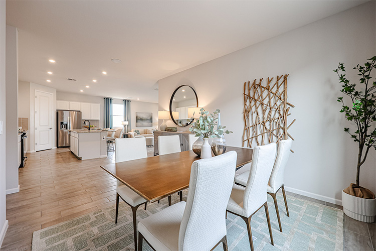 A dining room with a table and chairs.