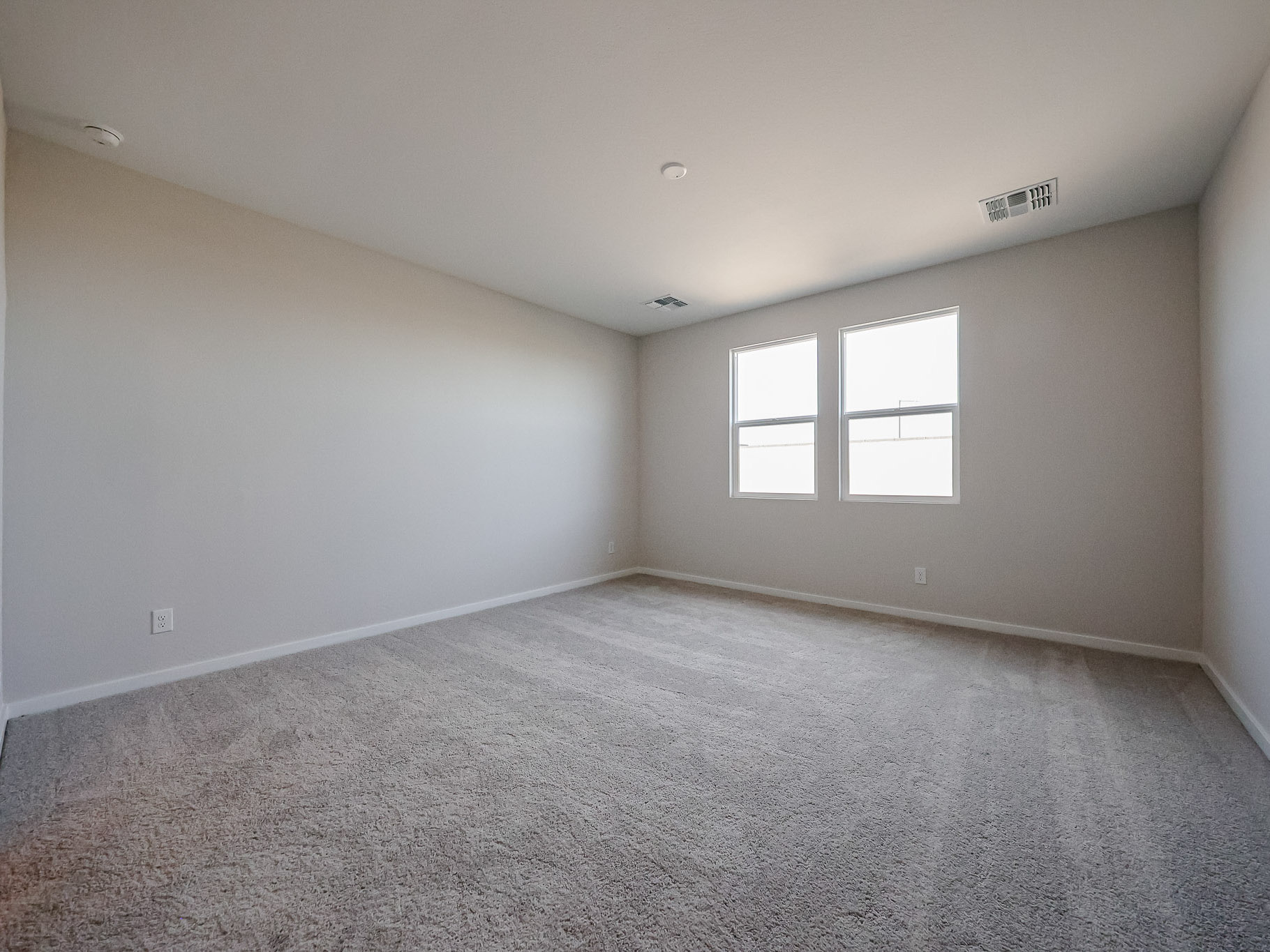 A room with a carpet and windows.