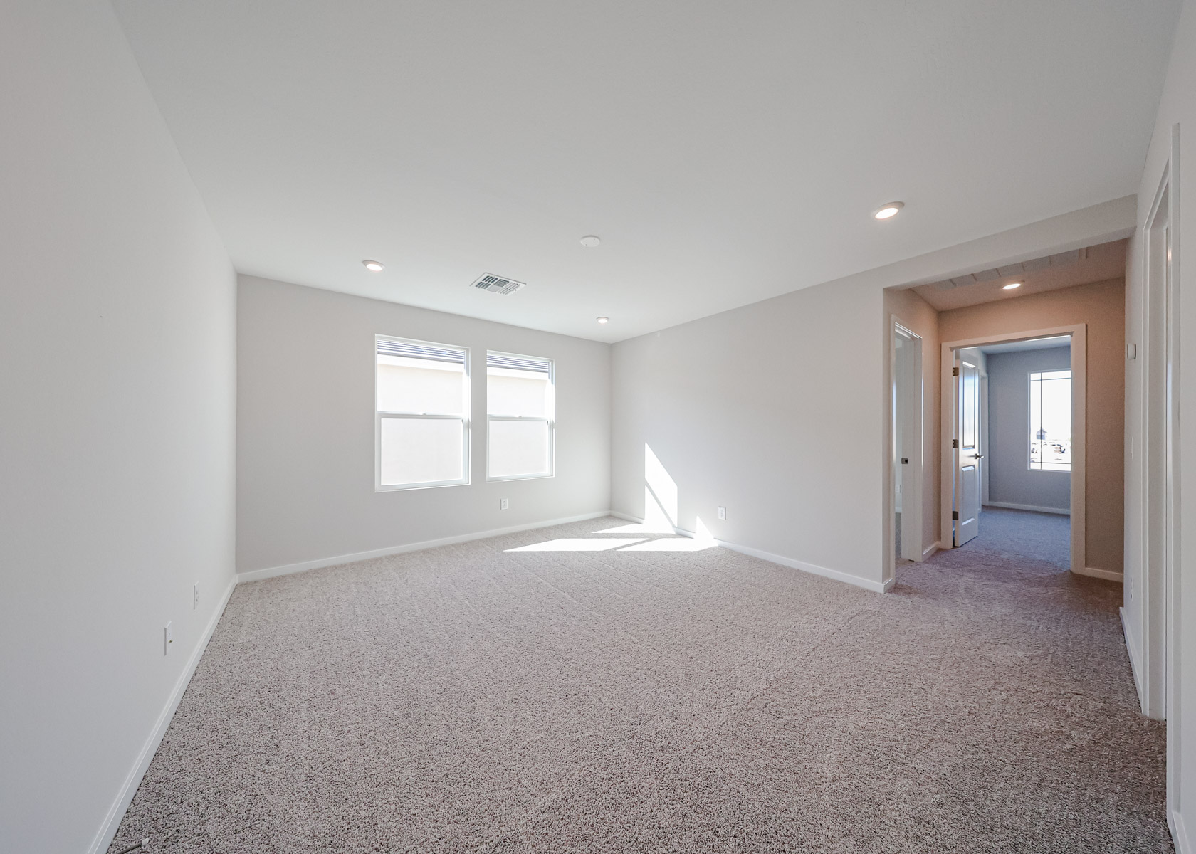 A room with a carpet and a window.