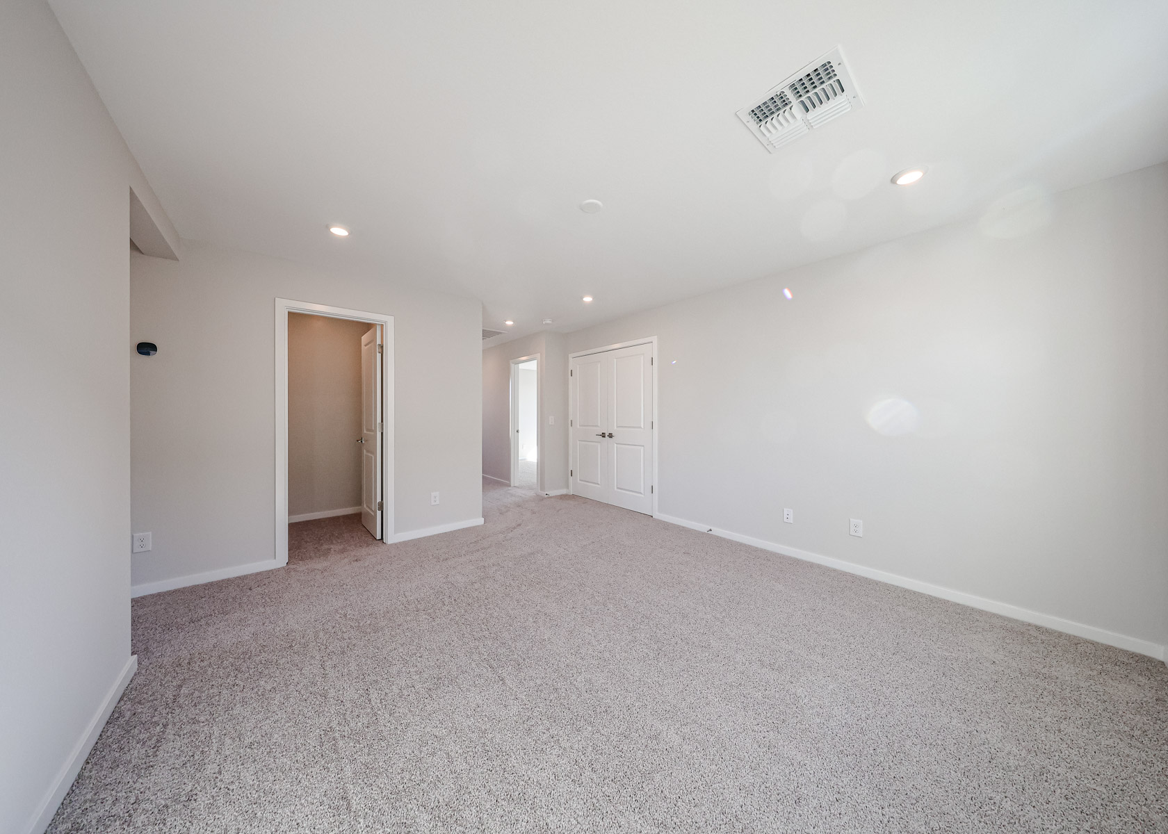 A long hallway with white doors.