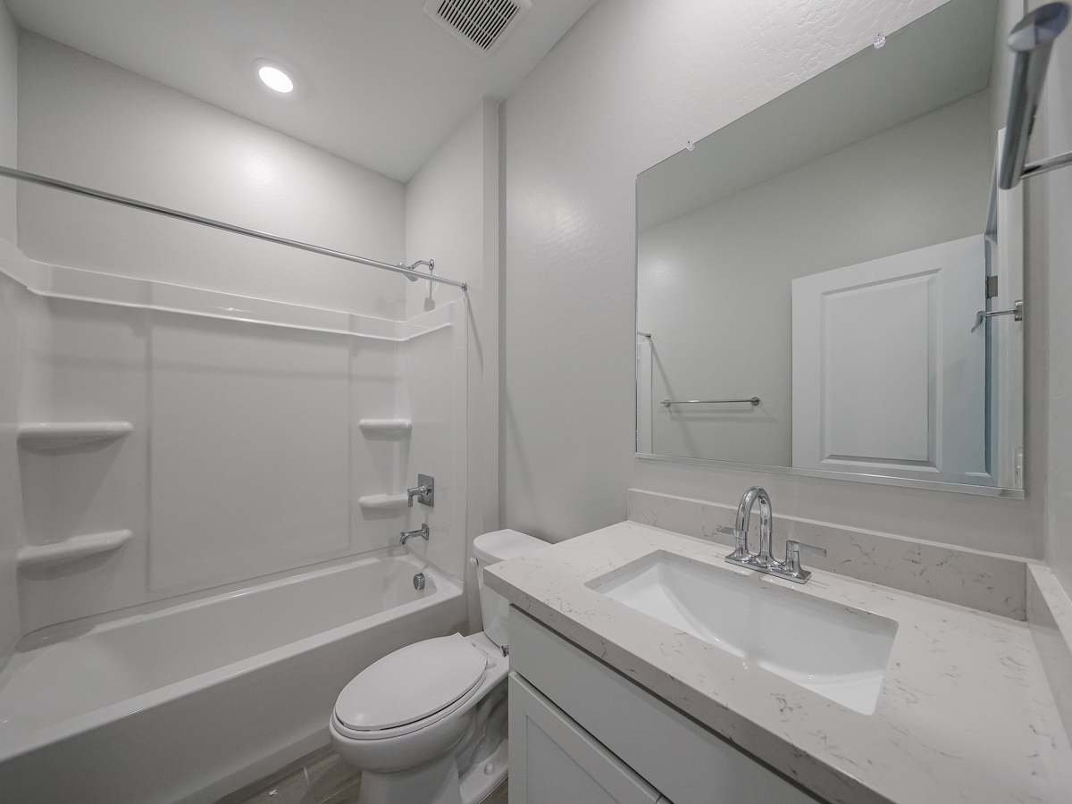 A bathroom with a tub sink and toilet.