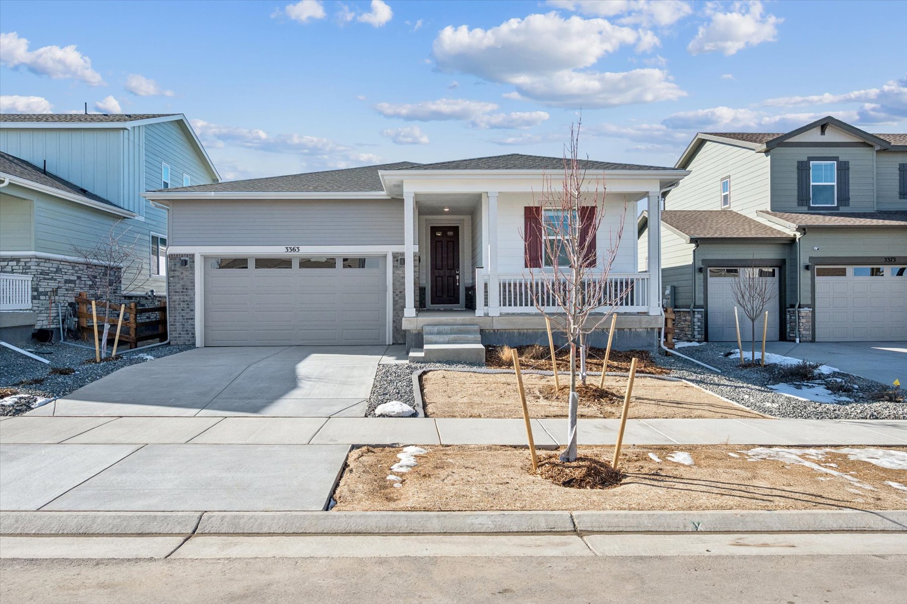 A house with a garage and a tree in the front.