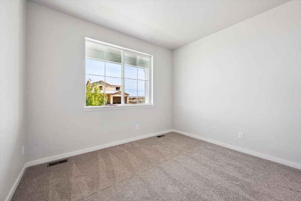 A room with a window and a carpet.