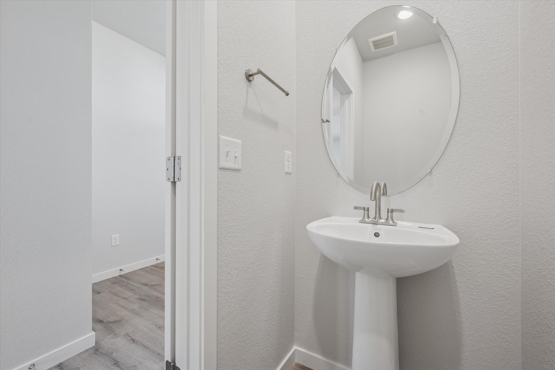 A bathroom with a round mirror.