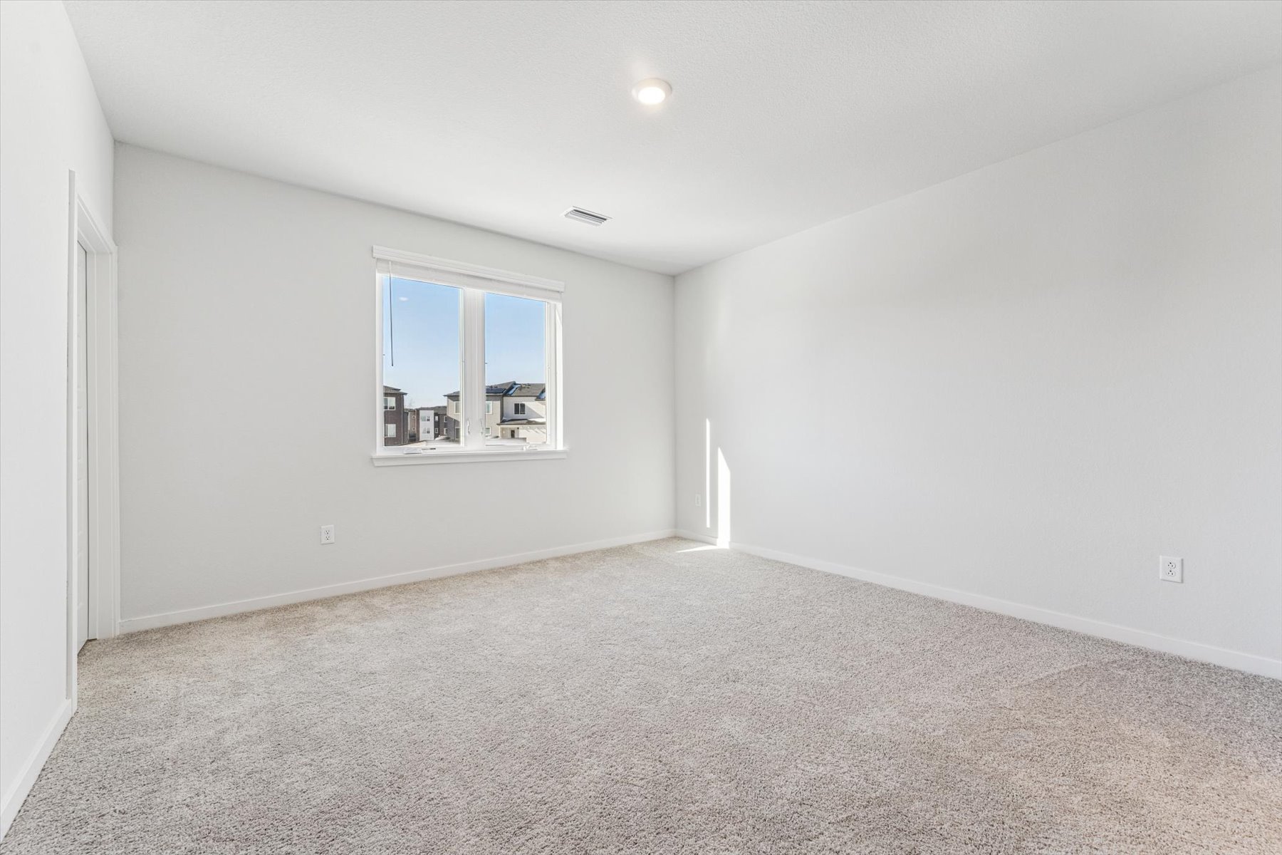 A room with a window and carpet.