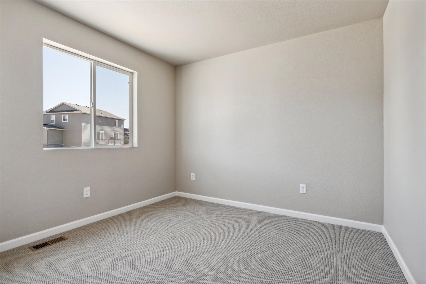 A room with a window and a rug.