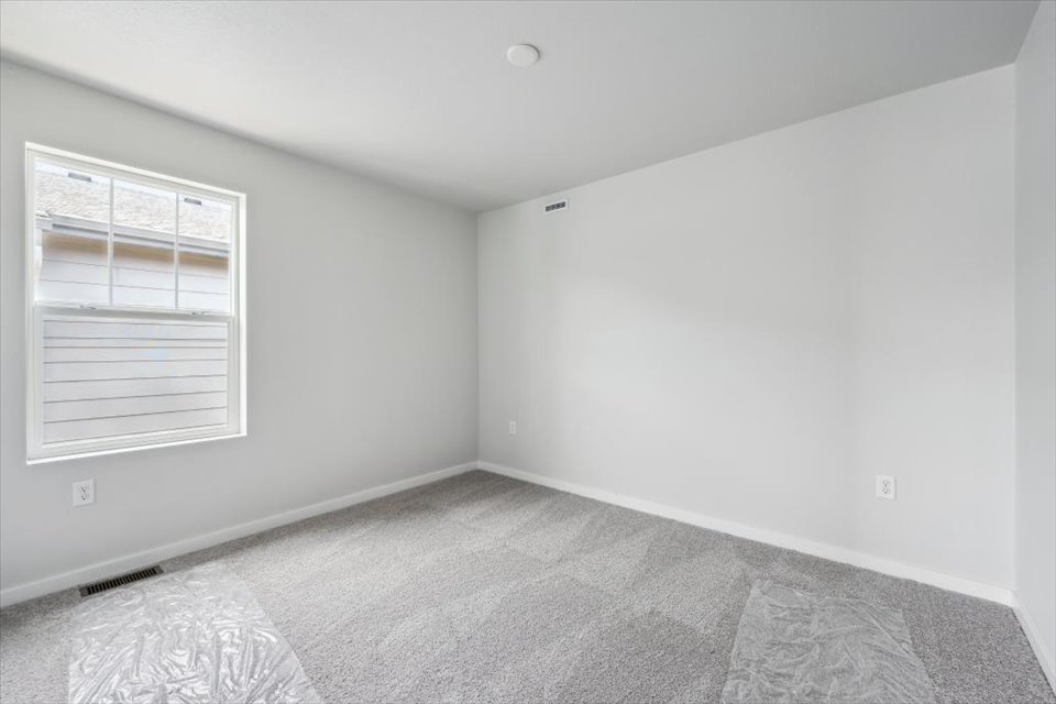 A room with a carpet and a window.