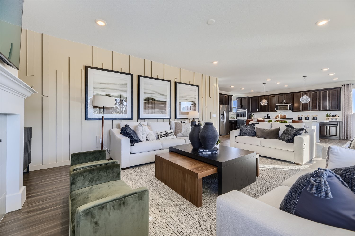 A living room with a large white couch and a wood floor.