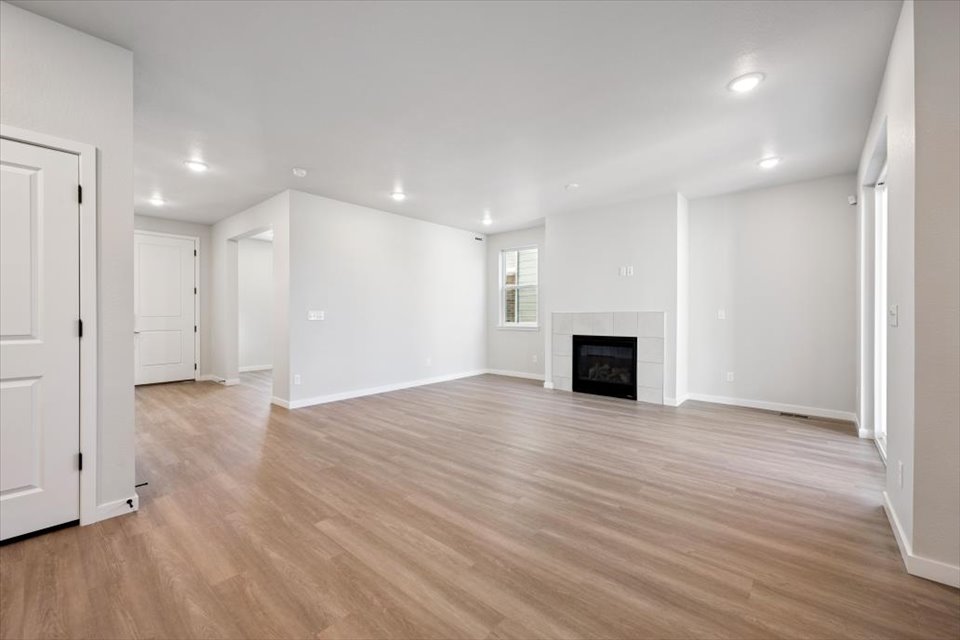 A large empty room with a fireplace.