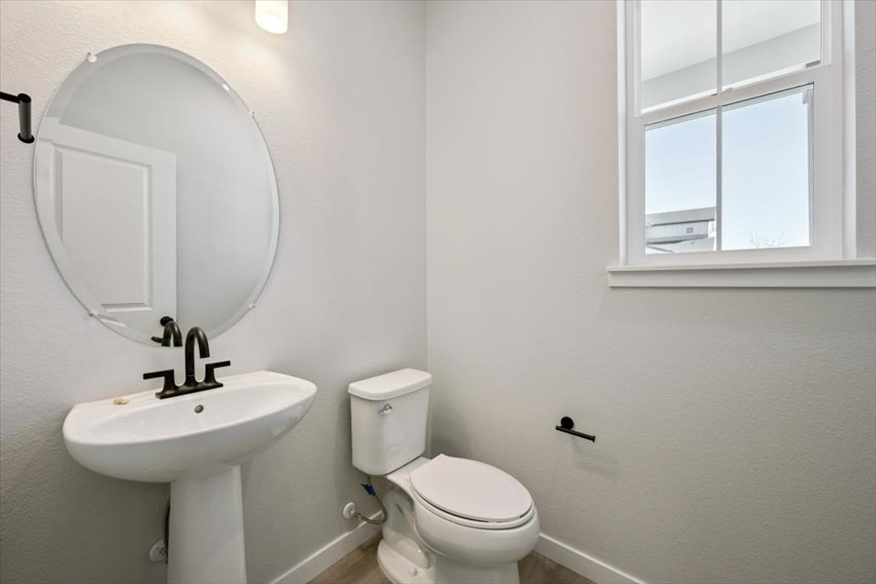 A bathroom with a round mirror.