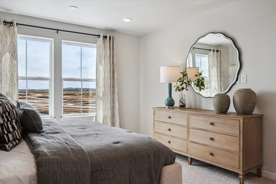 A bedroom with a large window.