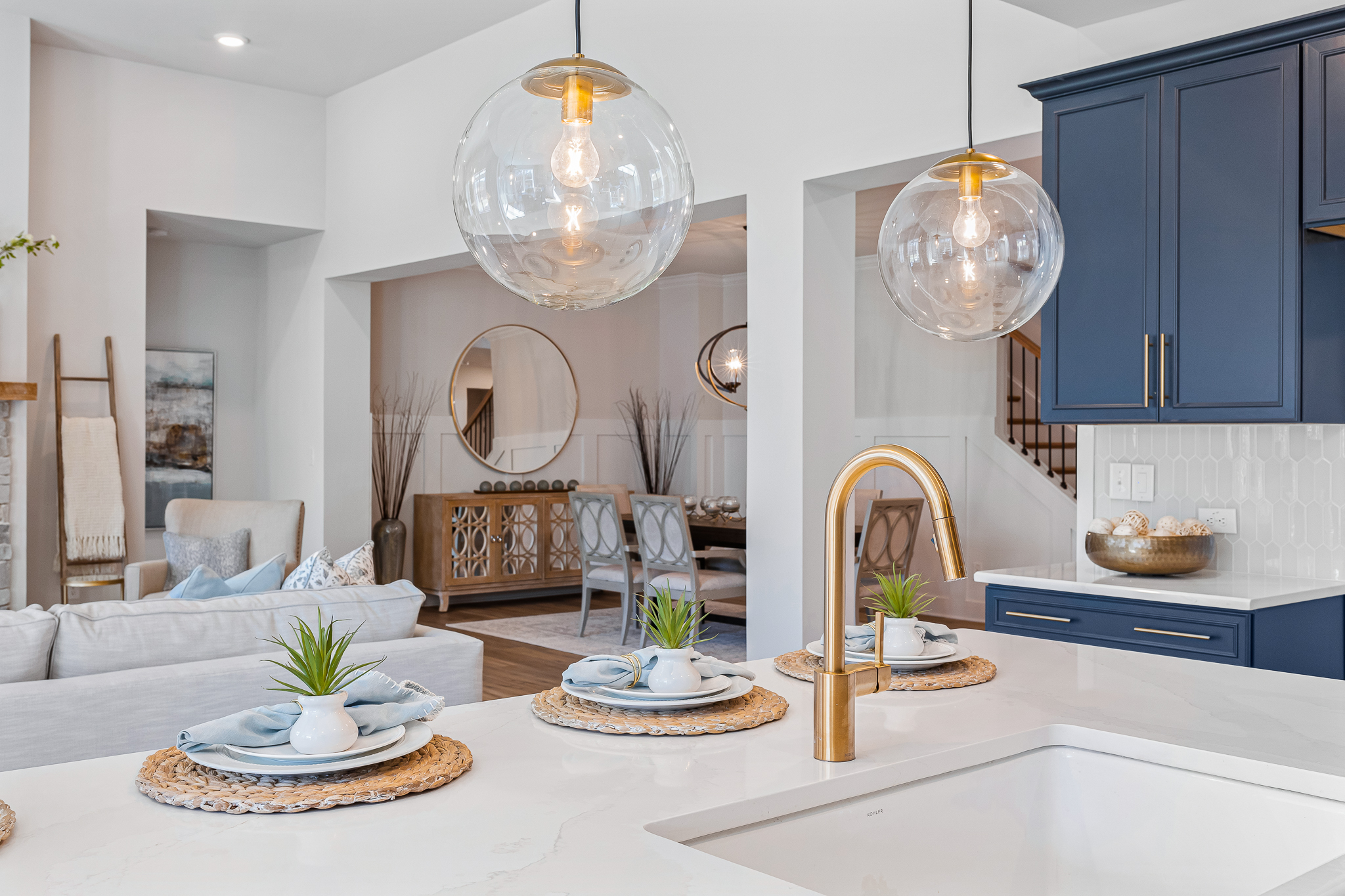A modern looking living room with a chandelier and a white table.