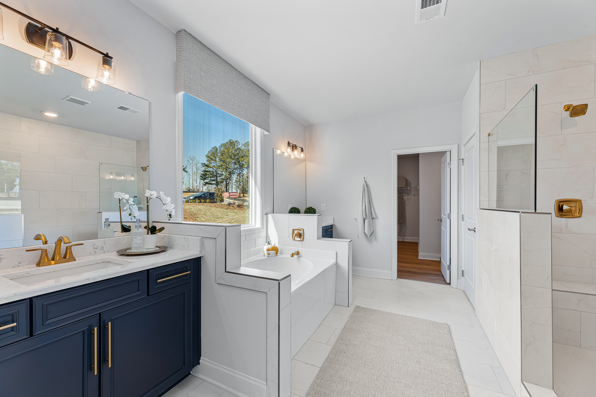 A bathroom with a tub sink and cabinets.