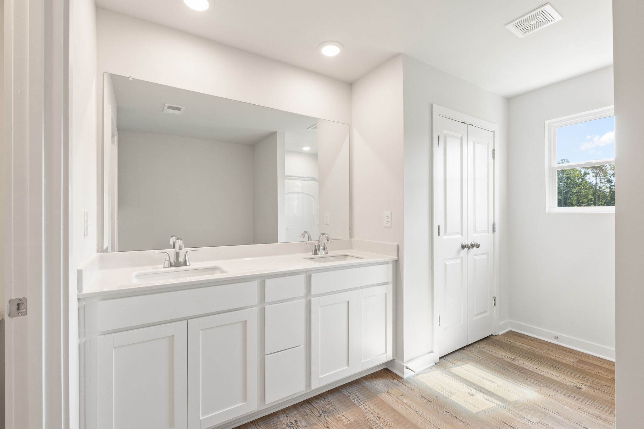 A bathroom with white cabinets.