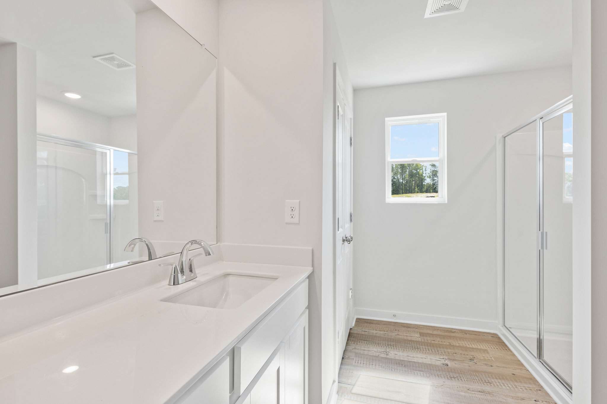 A bathroom with a sink and a shower.